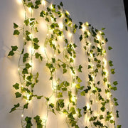 Brighten up your space with these flower and green leaf string lights—artificial vine style for a touch of nature's glow!