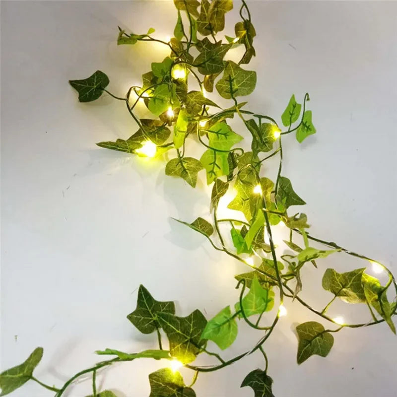 Brighten up your space with these flower and green leaf string lights—artificial vine style for a touch of nature's glow!