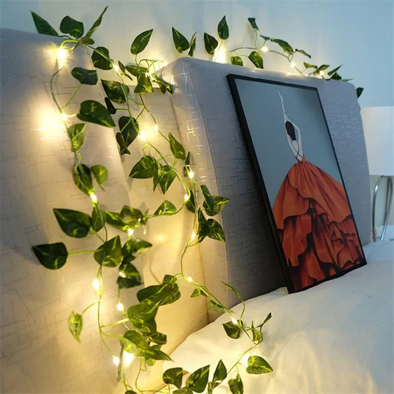 Brighten up your space with these flower and green leaf string lights—artificial vine style for a touch of nature's glow!