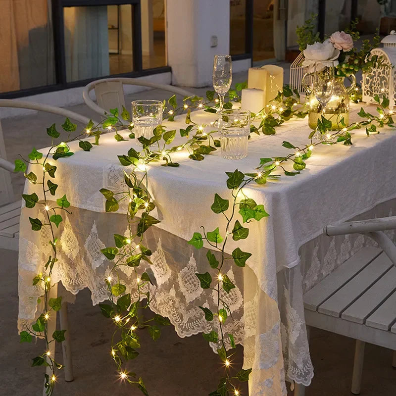 Brighten up your space with these flower and green leaf string lights—artificial vine style for a touch of nature's glow!
