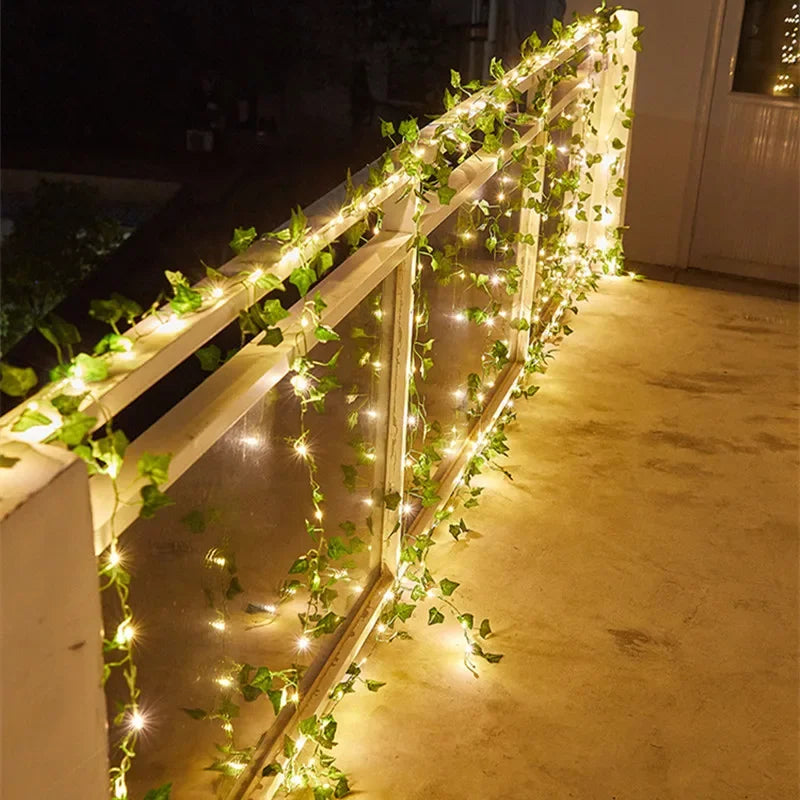 Brighten up your space with these flower and green leaf string lights—artificial vine style for a touch of nature's glow!