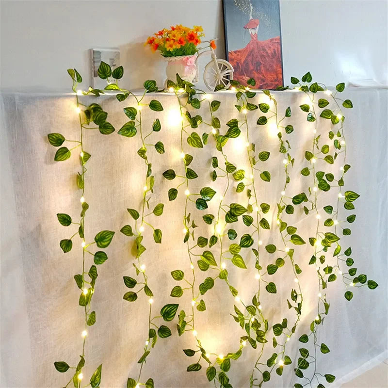 Brighten up your space with these flower and green leaf string lights—artificial vine style for a touch of nature's glow!