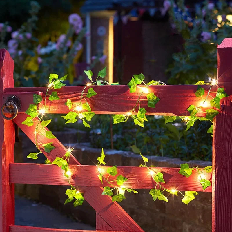 Brighten up your space with these flower and green leaf string lights—artificial vine style for a touch of nature's glow!